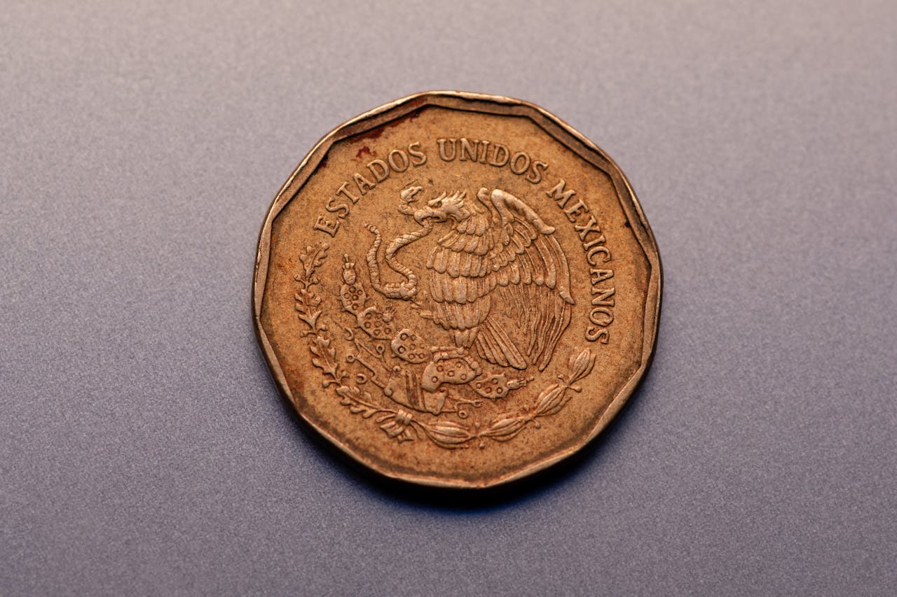 Home High-resolution close-up of a copper Mexican coin featuring national emblem on gray surface.